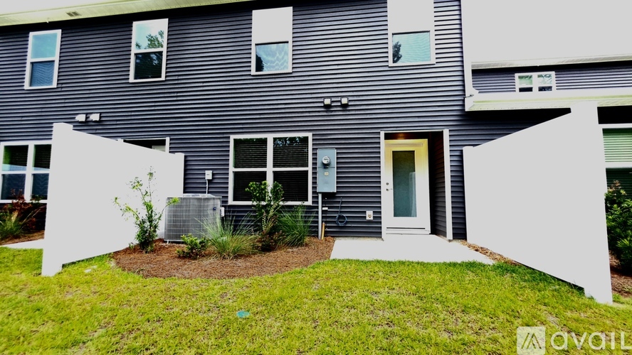 A modern house with a grey exterior and a white front yard.