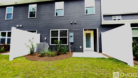 A modern house with a grey exterior and a white front yard.