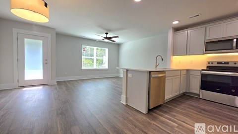 A kitchen with a stove top oven and a fan on the ceiling.