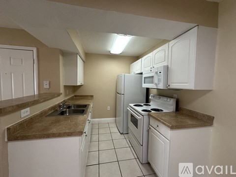 A kitchen with white cabinets and a brown countertop.