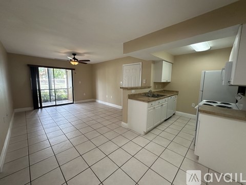 A kitchen with white cabinets and a tile floor.
