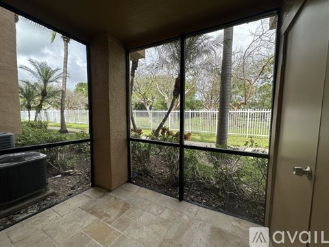 A balcony with a view of a fence and trees.