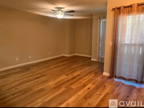 A room with wooden flooring and a ceiling fan.