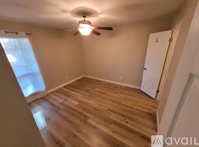 A room with wooden flooring and a ceiling fan.