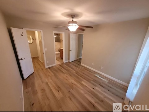 A room with wooden floors and a ceiling fan.