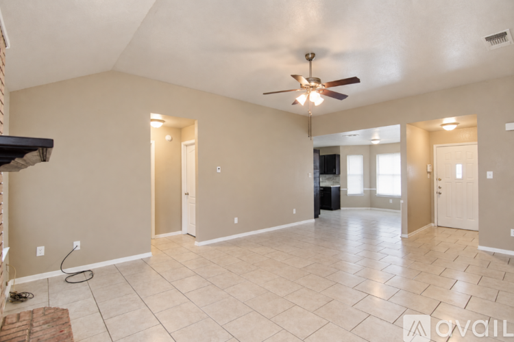A spacious room with a ceiling fan and tile flooring.