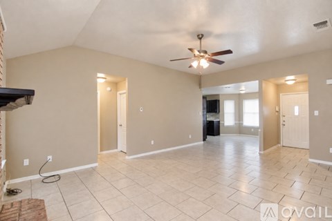 A spacious room with a ceiling fan and tile flooring.
