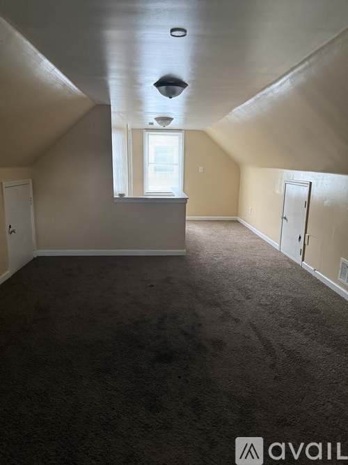 A room with a carpeted floor and a window.
