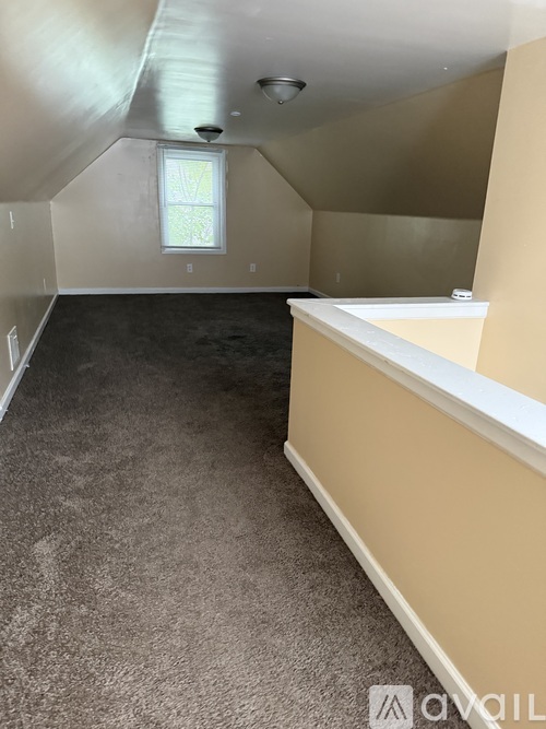 A room with a window and carpeted floor.