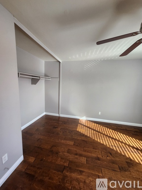 A room with wooden flooring and a ceiling fan.