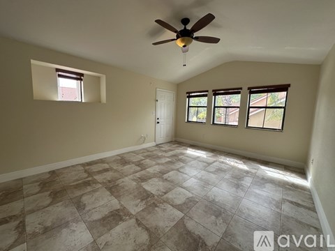 A room with a ceiling fan and tiled flooring.