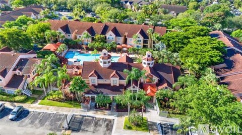 A bird's eye view of a residential area with houses and a swimming pool.