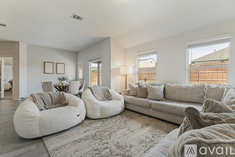 A living room with a grey sofa and two bean bag chairs.