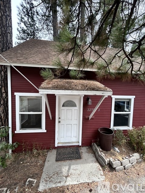 A red house with a white door and a brown roof.