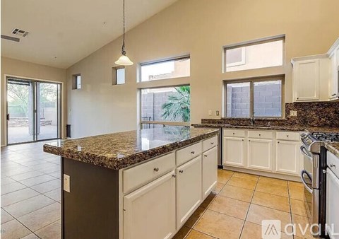 A kitchen with granite countertops and white cabinets.