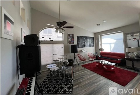 A living room with a red rug and a black speaker.