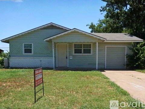 A house with a sign in front that says "For Sale".