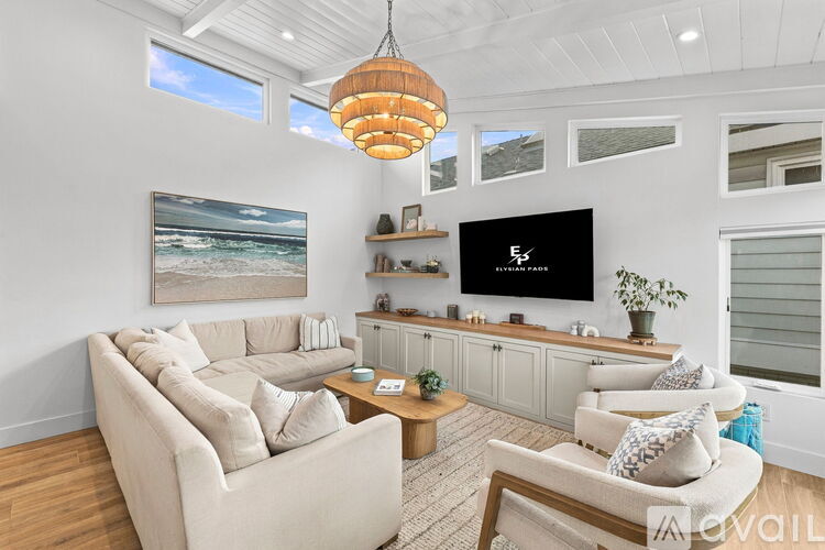 A living room with a large couch and a flat screen TV mounted on the wall.
