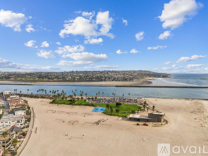 A beach with a swimming pool and a building with the word "AVAILABLE" on it.