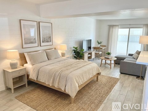 A bedroom with a large bed, a couch, and a TV.