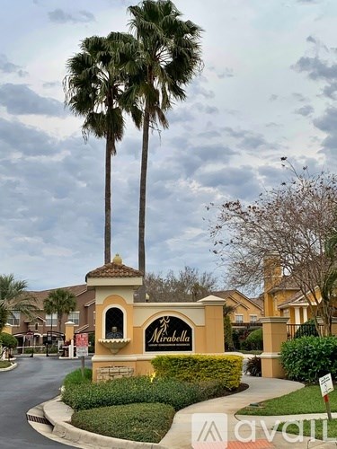 A sign for a place called "Mirabella" is in front of some trees.