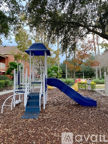 A playground with a blue slide and a white and blue tower.