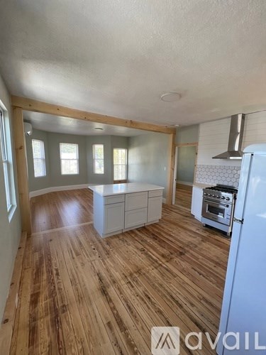 A kitchen with wooden floors and white walls.