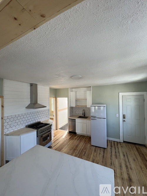 A kitchen with a white fridge and a stove top oven.