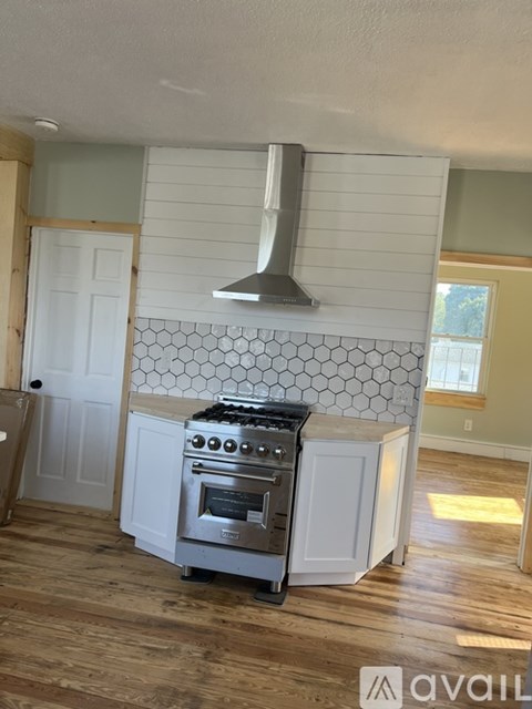 A kitchen with a stove and a hood.