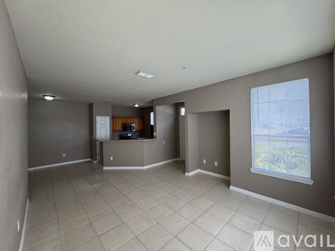 A spacious living room with a flat screen TV and a large window.