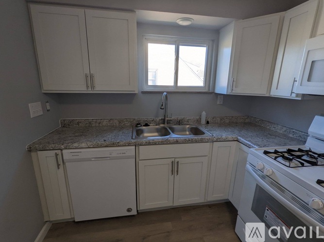 A kitchen with white cabinets and a granite countertop.