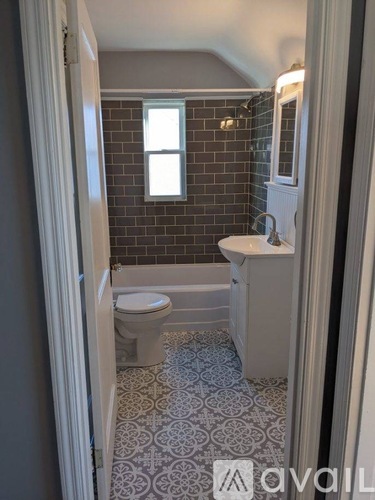 A bathroom with a toilet, sink, and a window.