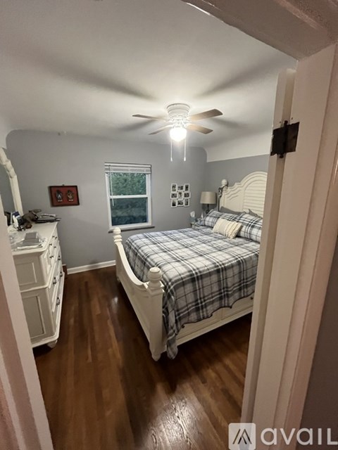 A bedroom with a bed, dresser, and window.