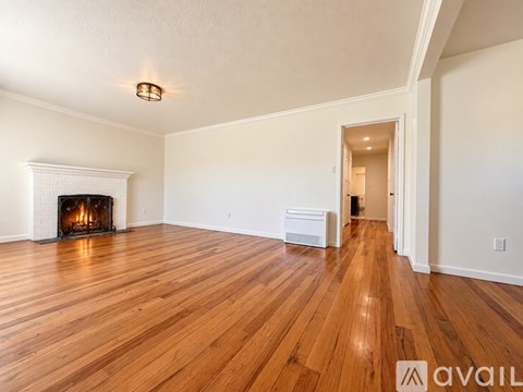 A room with a fireplace and wooden floors.