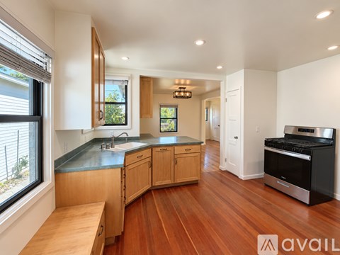 A kitchen with wooden cabinets and a black stove top oven.