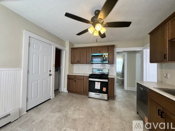 A kitchen with a fan and a stove top oven.