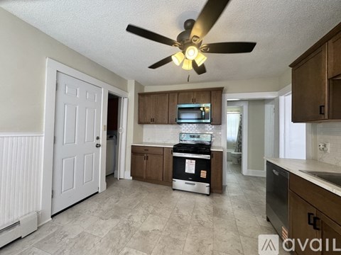 A kitchen with a fan and a stove top oven.