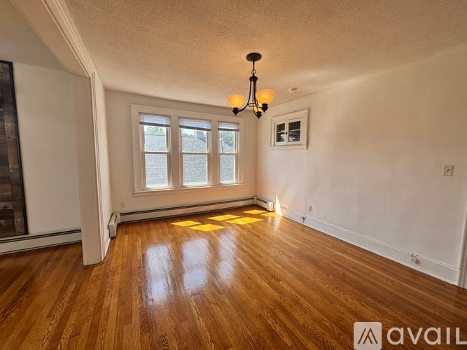 A room with wooden floors and a chandelier.