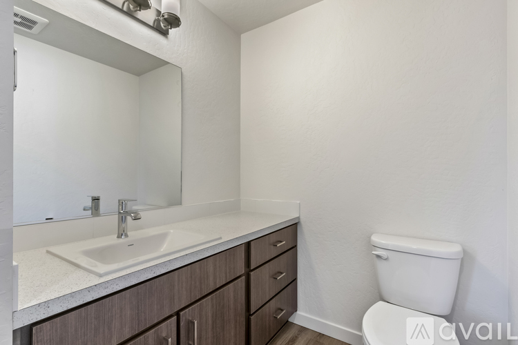 A bathroom with a sink, mirror, and toilet.