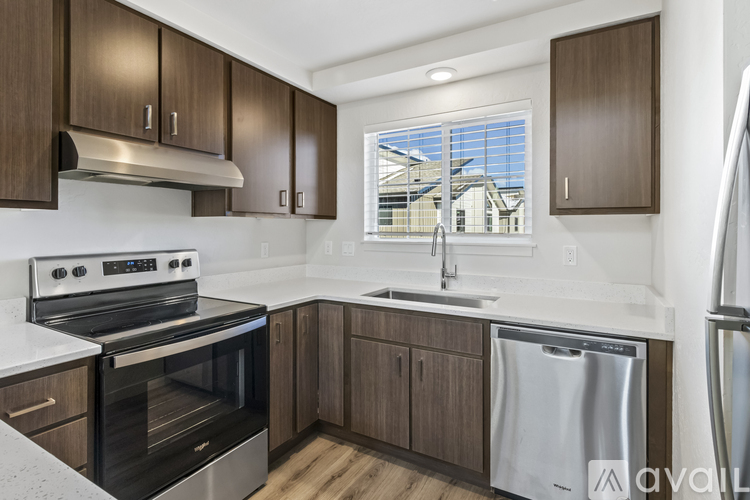 A kitchen with a stove, sink, and cabinets.