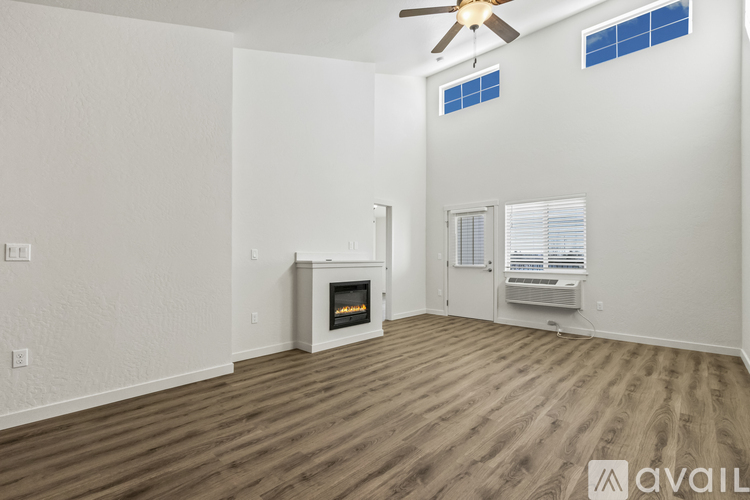 A room with a fireplace and a fan on the ceiling.