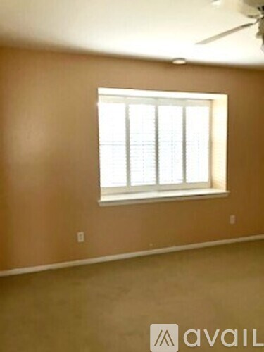 A room with a window and a ceiling fan.