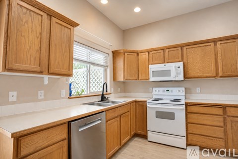 A kitchen with wooden cabinets and white appliances.