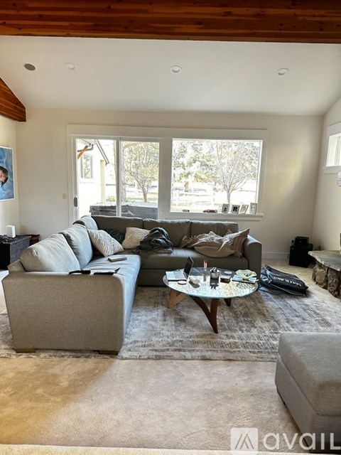 A living room with a grey couch and a coffee table.