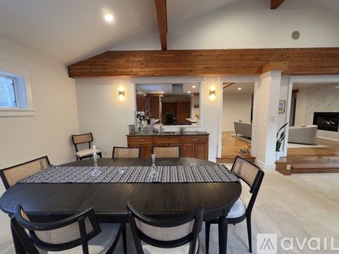 A dining room with a large table and chairs.