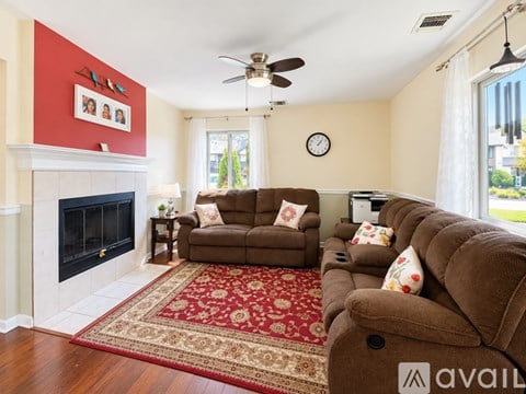 A living room with a fireplace and a brown couch.