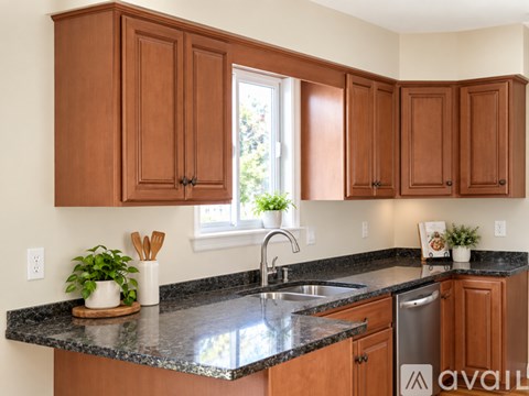A kitchen with brown cabinets and a granite countertop.