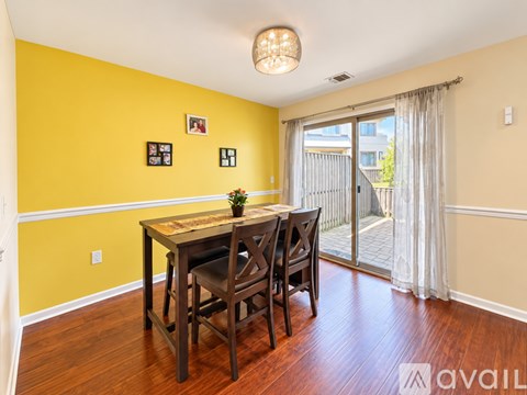 A dining room with a wooden table and chairs.