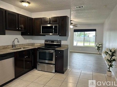A kitchen with black cabinets and stainless steel appliances.