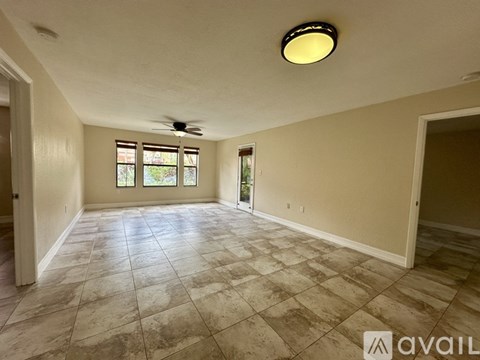A spacious room with tiled flooring and a ceiling fan.
